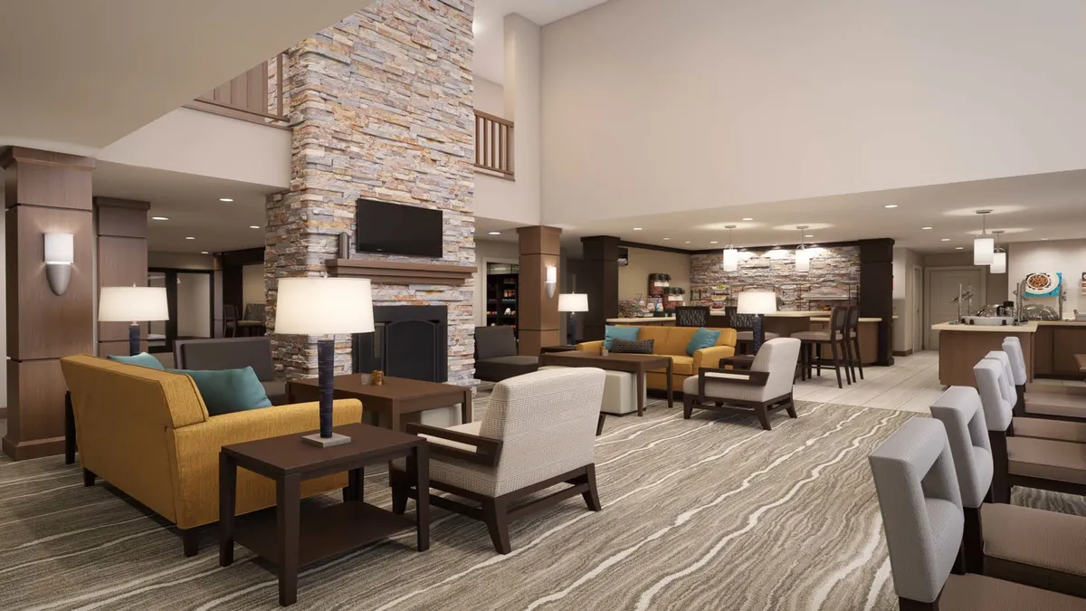 A cozy common area with a stone fireplace, plush seating, and modern decor. The space invites relaxation, with guests able to socialize, read, or simply unwind in an inviting atmosphere that feels safe and welcoming for solo guests.
